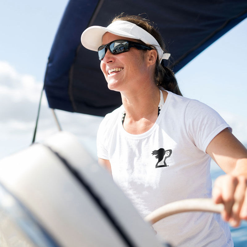 Image of woman sailing a yacht wearing a t-shirt from Harbor Springer, a Harbor Springs, Michigan clothing store and brand.
