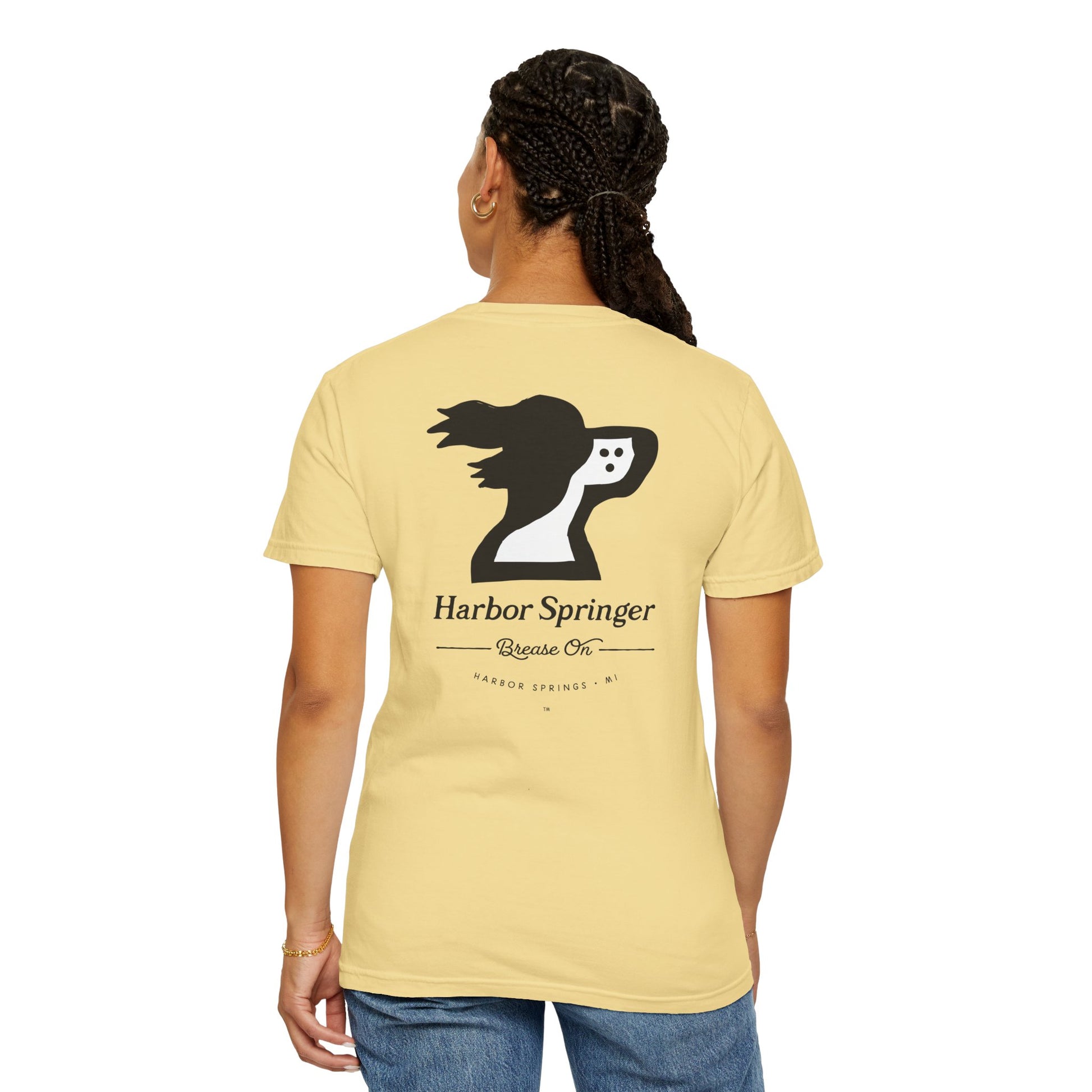 Woman wearing light yellow tee by the Harbor Springer brand with a springer spaniel dog logo and Brease On tagline on the back.