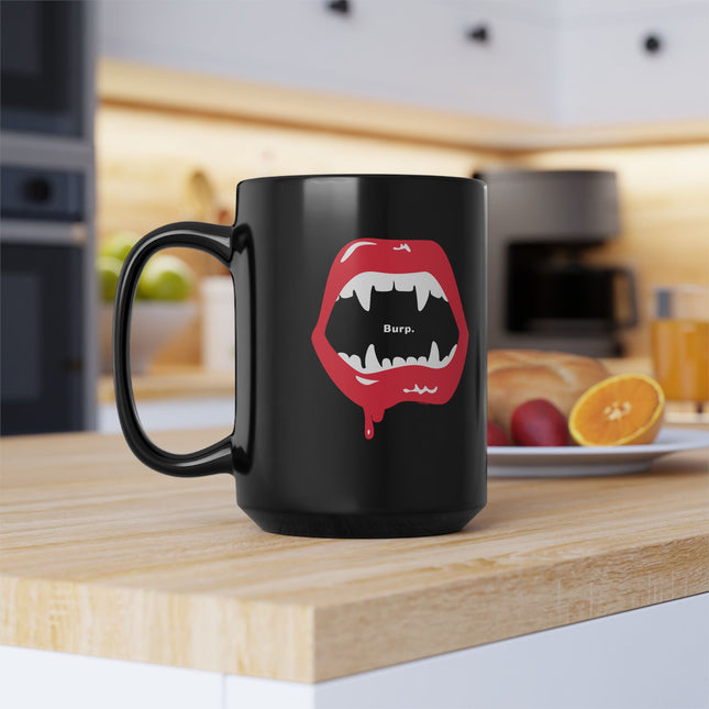 Burp Fangs black ceramic mug 15oz, studio shot — spooky funny coffee mug
