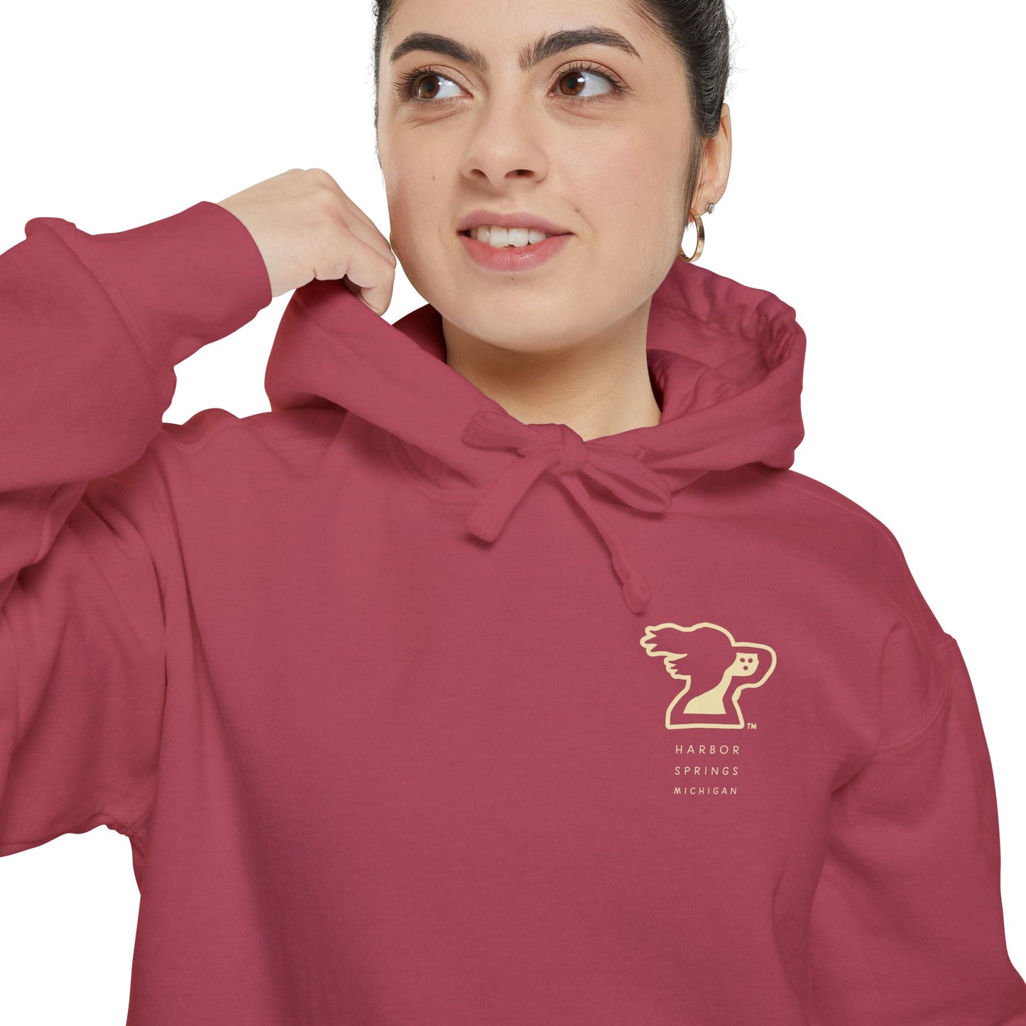 Woman wearing red color hoodie by the Harbor Springer brand with a springer spaniel dog logo and Harbor Springs Michigan text.