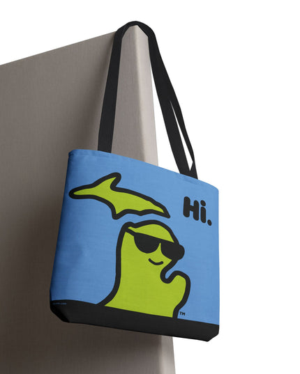 Closeup of a Michigan tote bag with a green Michigan-shaped character wearing sunglasses and smiling and saying "Hi" on a blue background.