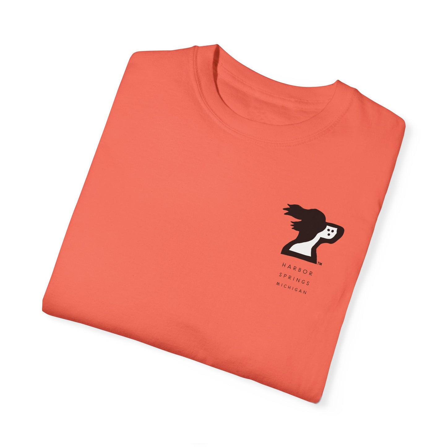 Folded salmon color t-shirt by the Harbor Springer brand with a springer spaniel dog logo and Harbor Springs Michigan text.