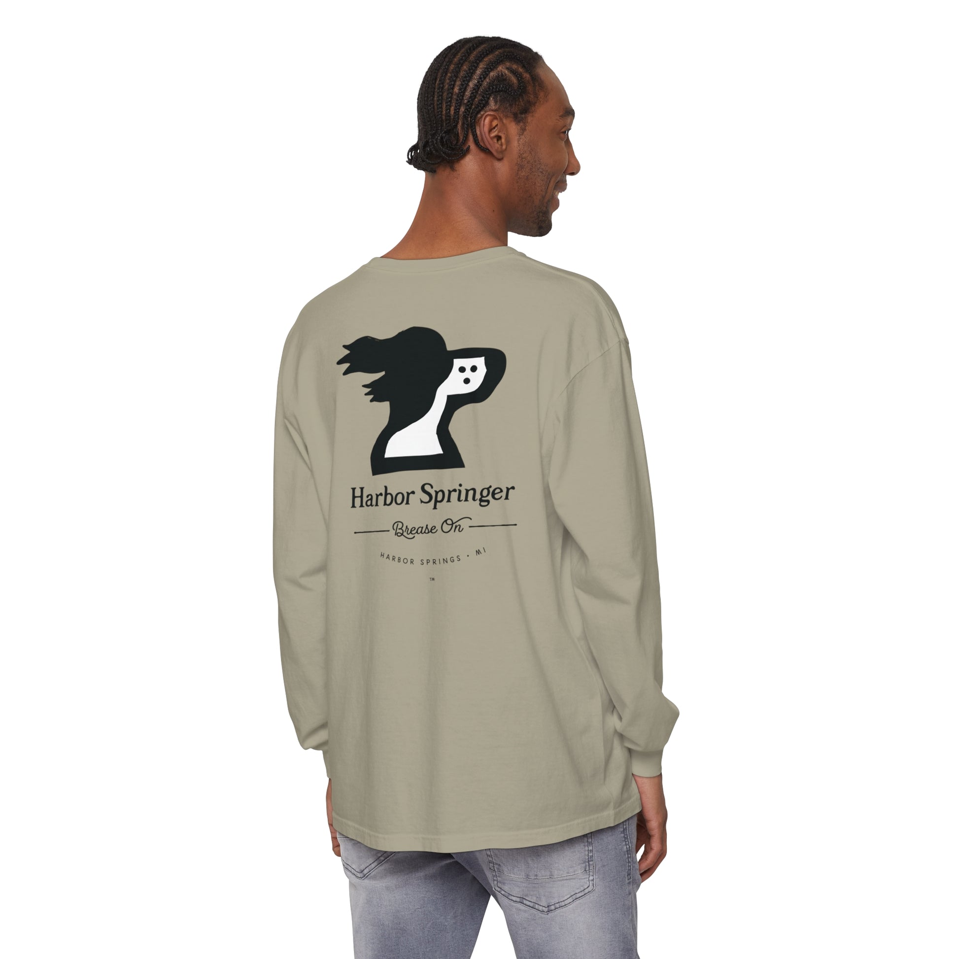 Man standing and wearing a tan long sleeve t-shirt by the Harbor Springer brand with a springer spaniel dog logo and Brease On tagline on the back.