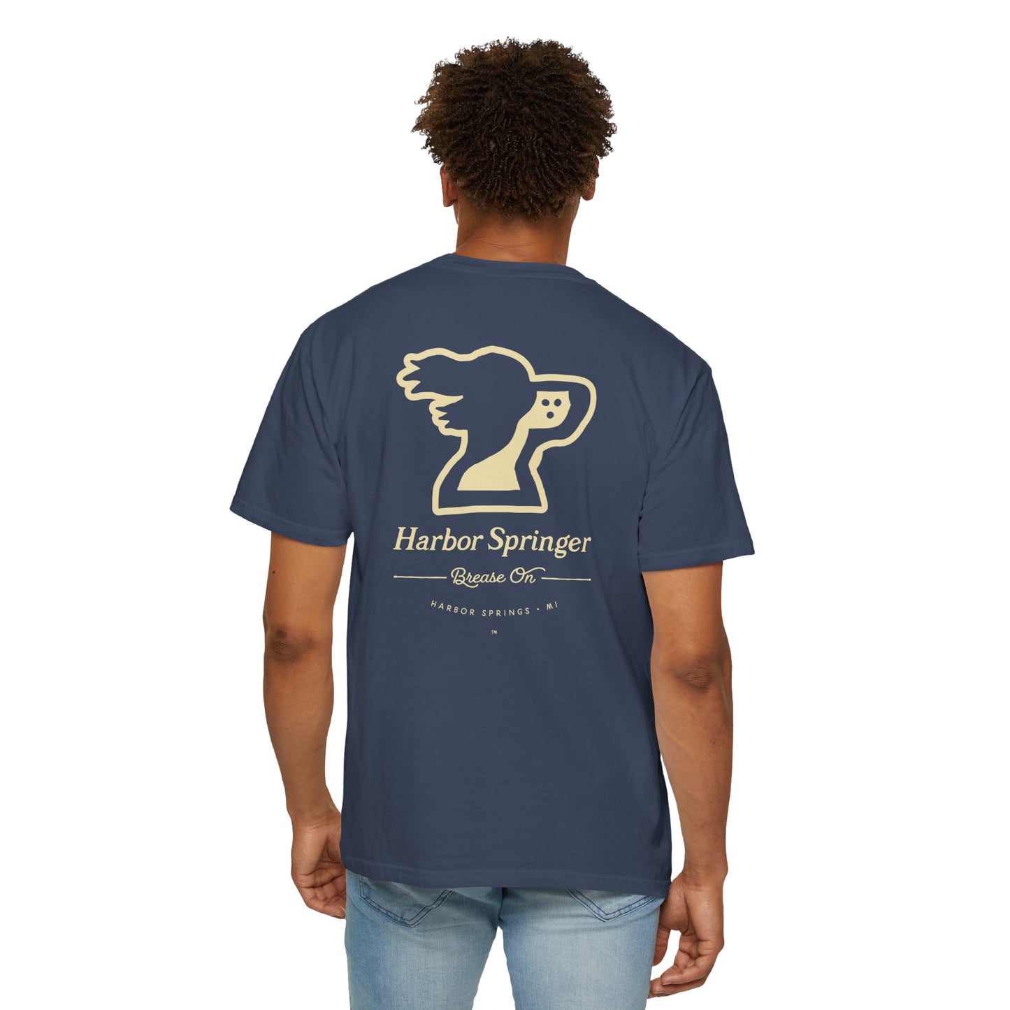 Standing man wearing a dark blue tee by the Harbor Springer brand with a springer spaniel dog logo and Brease On tagline on the back.