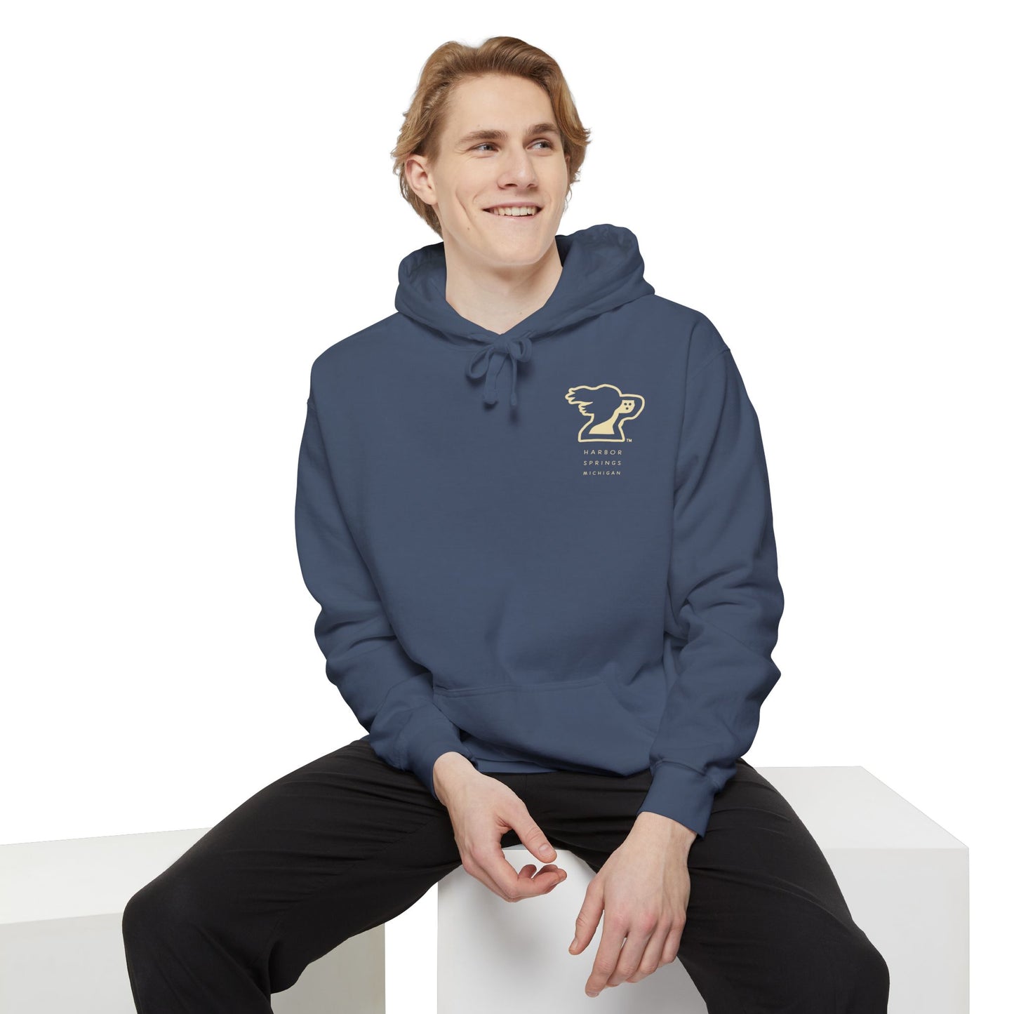 Man wearing a blue color hoodie by the Harbor Springer brand with a springer spaniel dog logo and Harbor Springs Michigan text.