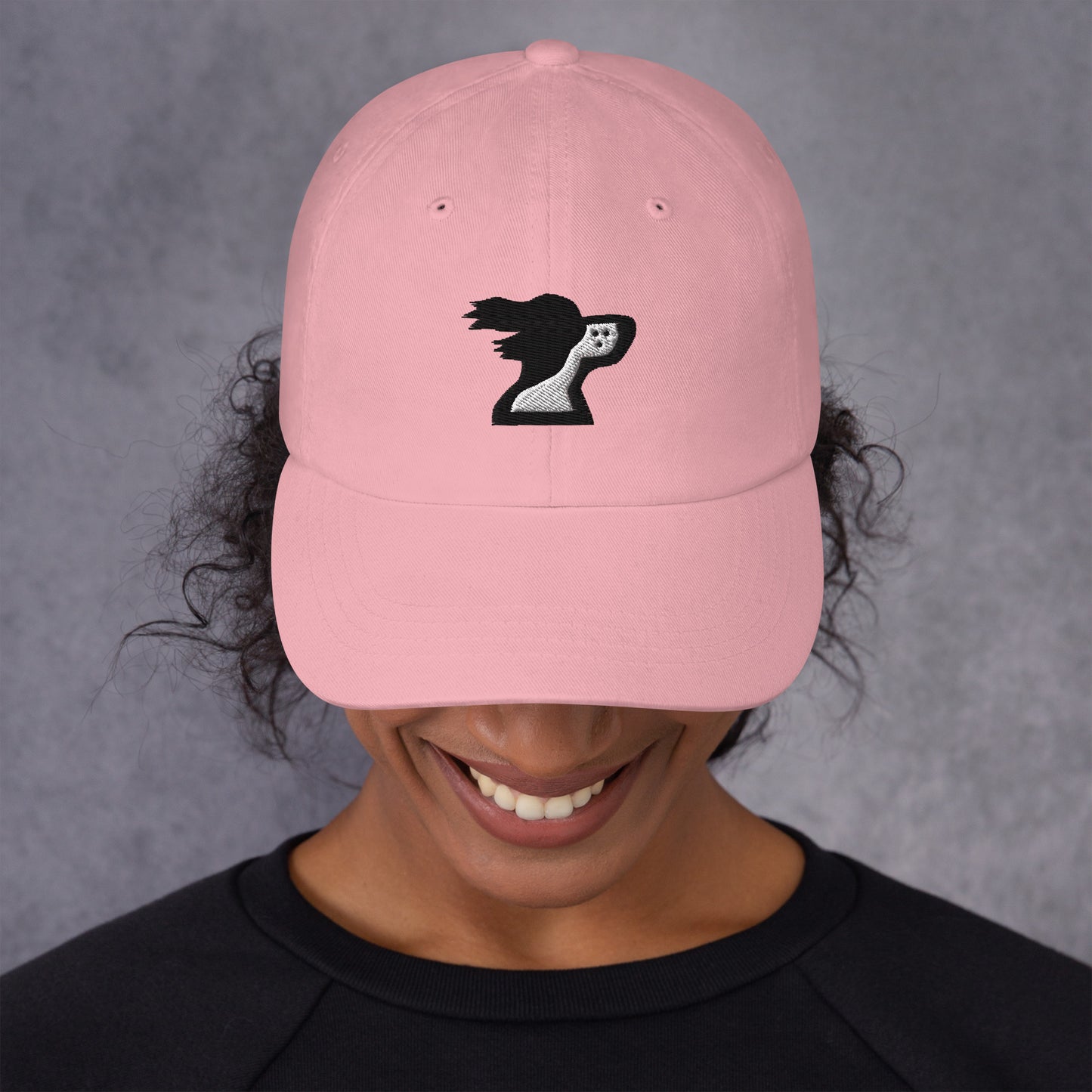 Woman wearing pink dad hat with brand logo by the Harbor Springer brand.