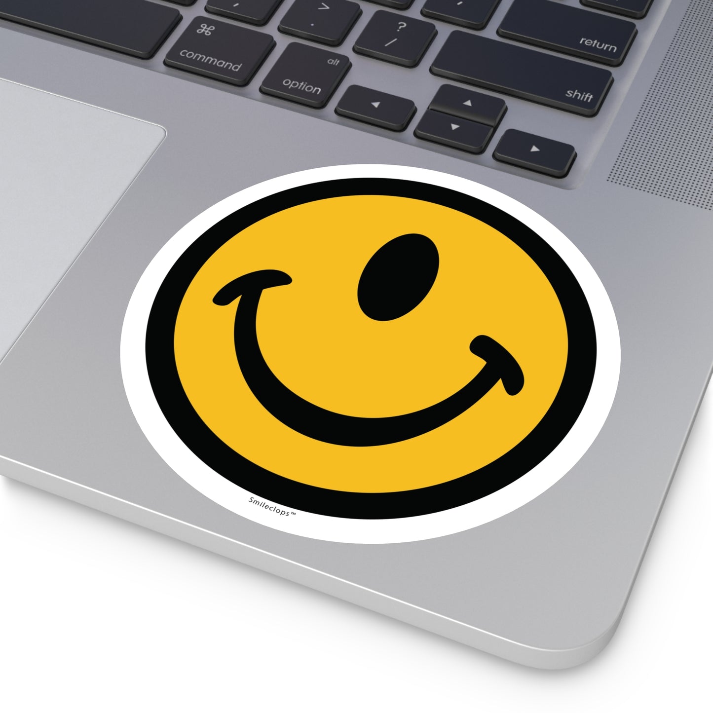 Extra large one-eyed smile face round sticker by the Smileclops™ brand on a laptop.