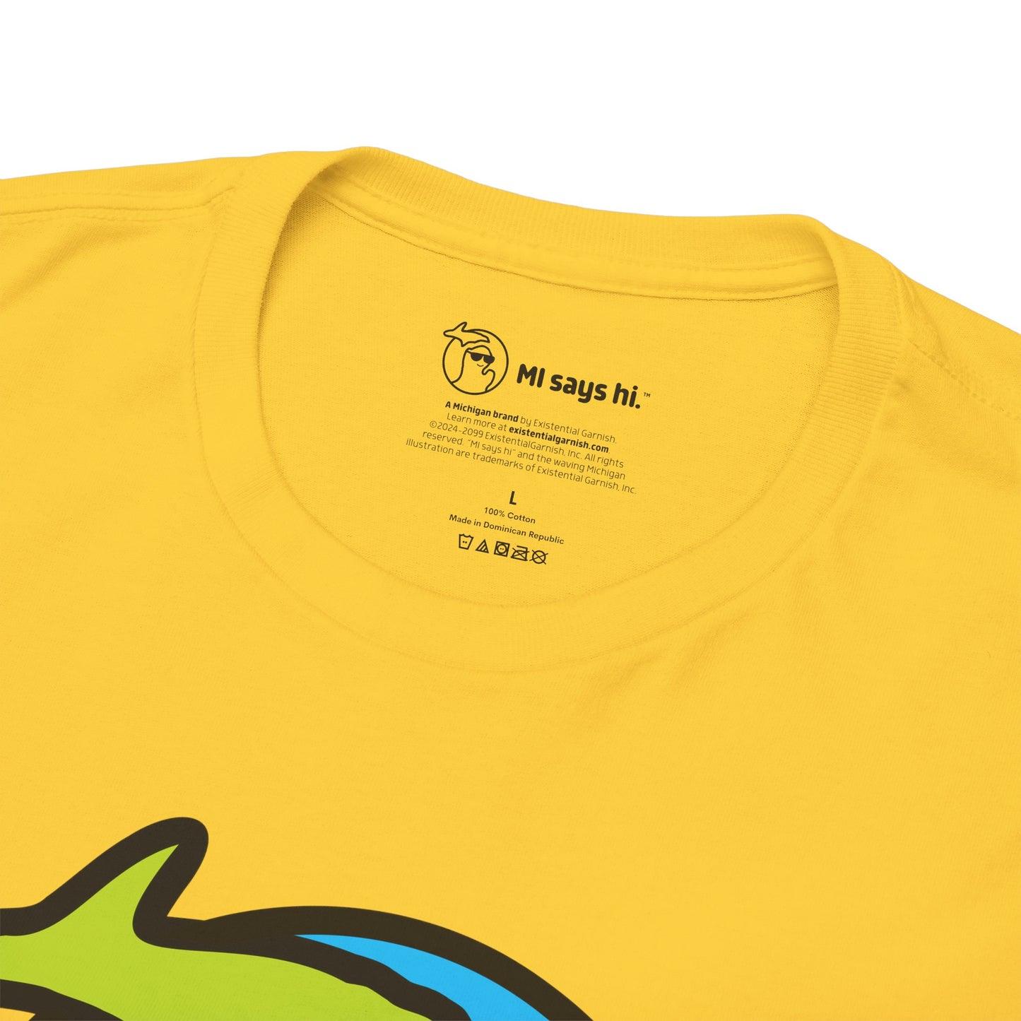 Close up of neck label of a yellow cotton t-shirts with a waving Michigan logo wearing sunglasses and smiling for the MI Says Hi brand.